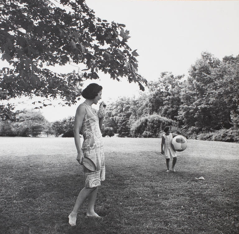 Formal portrait of mother and child with beach ball on lawn