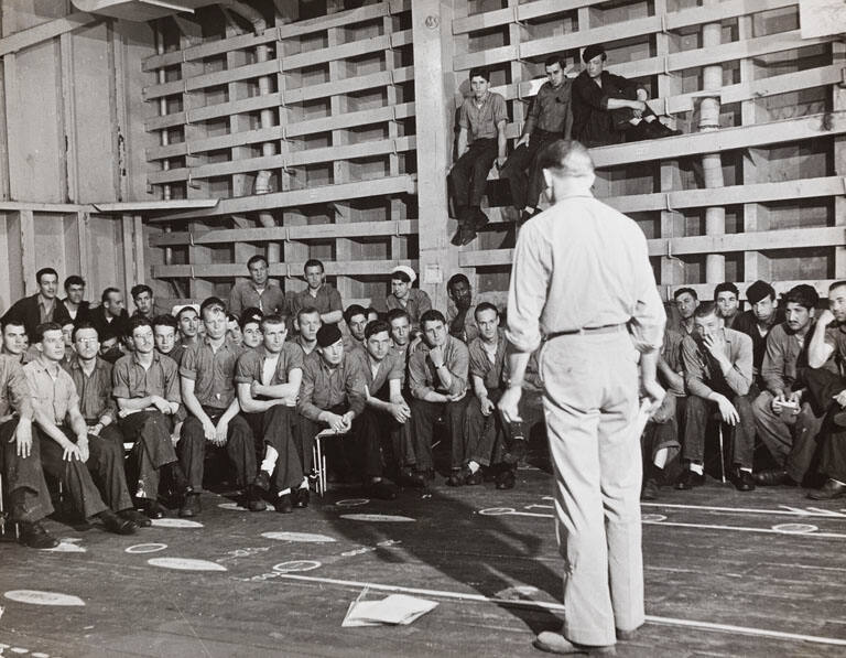 [Troops listening to orders aboard ship]