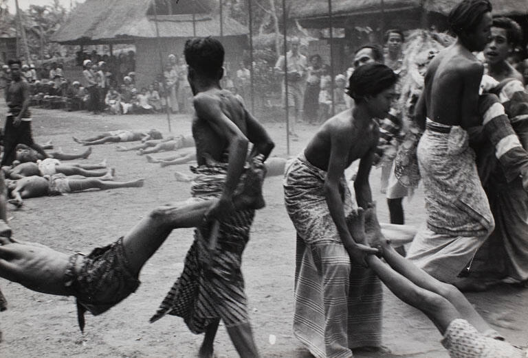 Kris dancers, who have danced themselves into a trance, being carried to the temple to be revived, Bali