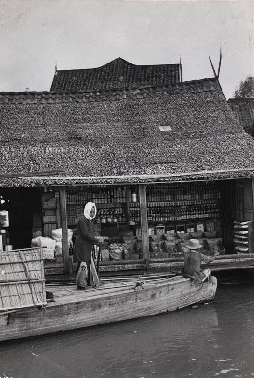 Longboat docking alongside floating shop on a house boat, Palembang, Sumatra