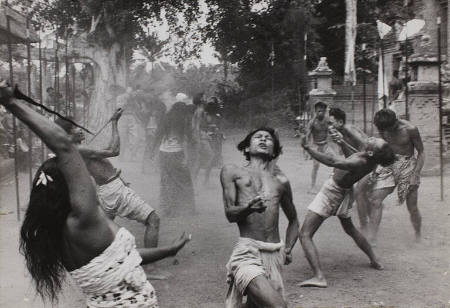 Spears in ground line either side of dance area as dancers wielding kris go into a trance, Bali, Indonesia