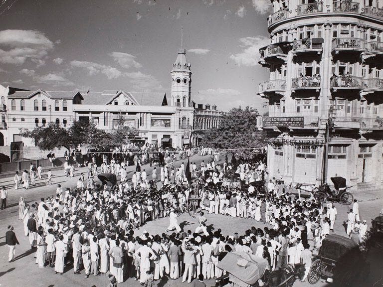 [Throng of celebrants surrounding two men performing ritual sword dance in celebration of the martyrdom of Hussain, Karachi, Pakistan]