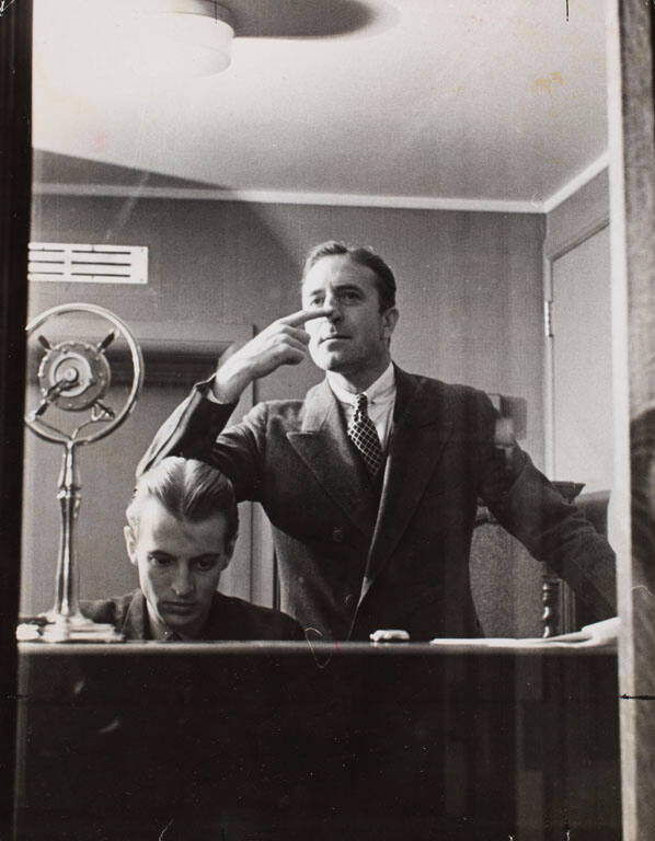 Radio program director making a timing signal for the actors on a show