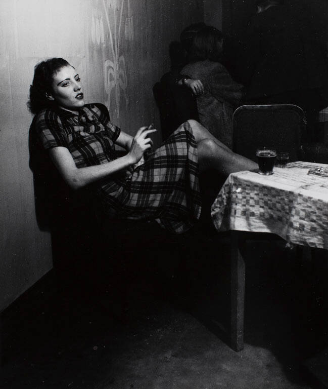 [Girl smoking, leaning backward in a chair]