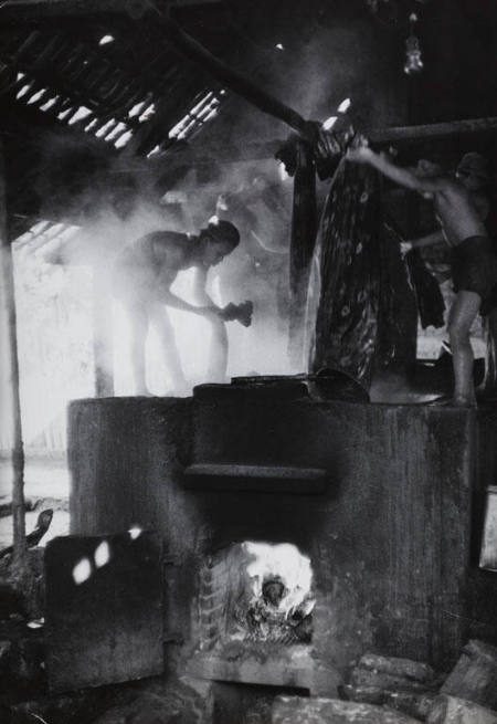 Large fire stoked under vats in a batik sarong factory, Indonesia