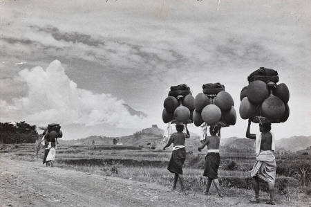 Women balancing huge earthen pots on their heads, heading to market in the old Balinese capital, Indonesia