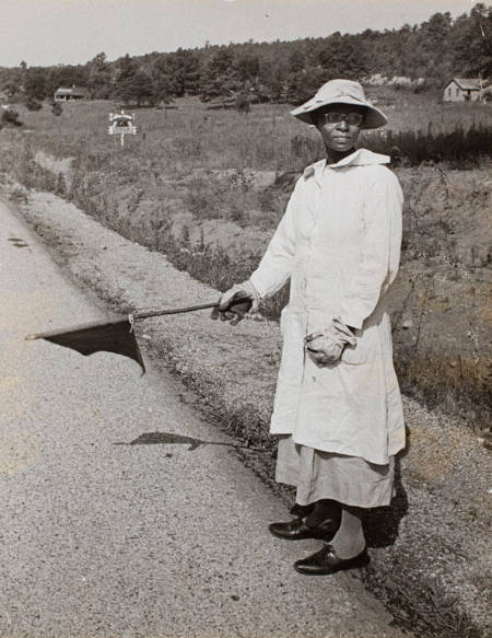 Woman waving flag to stop cars for the workers' safety on the roadside of the WPA Project, Birmingham, Alabama