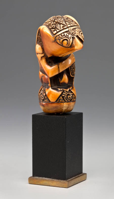 Kris handle; light golden brown, with darker "niello" effect within incised carvings