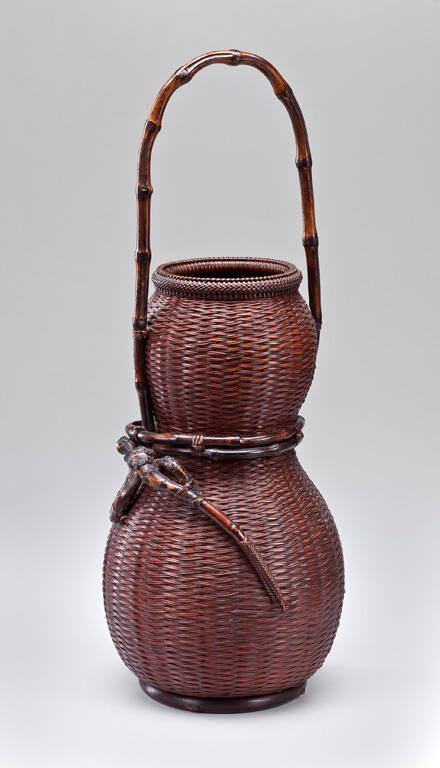 "Hourglass" basket with a long, naturally segmented bamboo handle