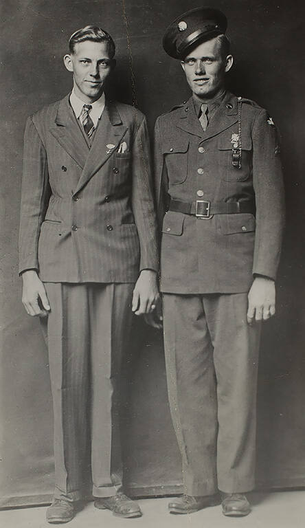 Two standing men, one wearing an Army uniform