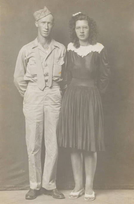 Military man in uniform with tie undone, and posed with bespectacled woman