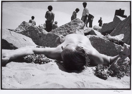 Man lying on the beach between rocks, New York