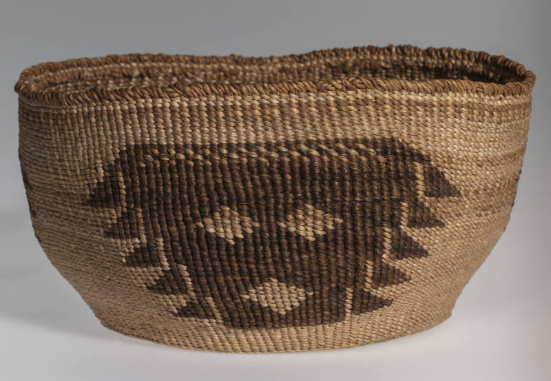 Basketry bowl with abstracted facial design repeated three times